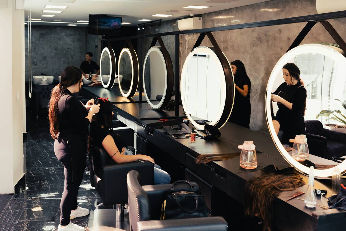 Professional applying hair treatment to damaged ends in salon setting